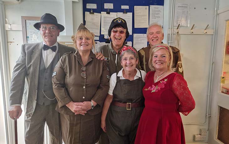A group of people dressed in olden day clothing posing for a picture.